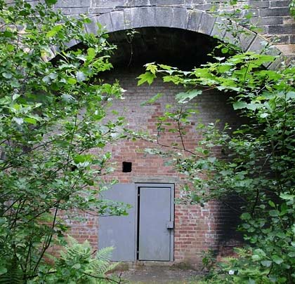 The bricked up western portal features a security door and bat holes.