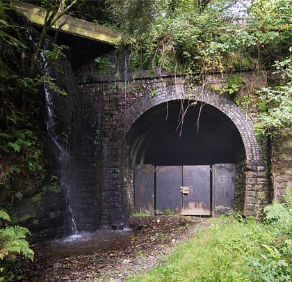 The south-west portal has a leaking aqueduct carrying a water channel over its corner and masonry buttresses at either side.