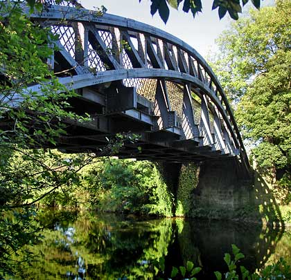 The bridge has found a secluded setting to span the river, maintaining its privacy from approaching walkers until the last moment.