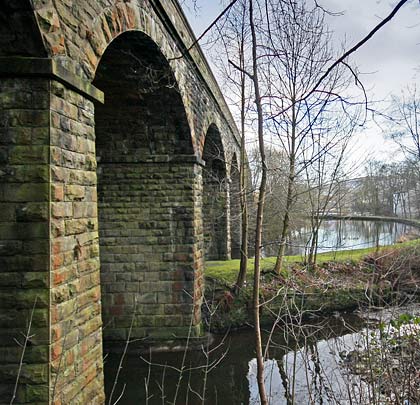 Helmshore's gently curved viaduct spans the River Ogden and runs alongside Higher Mill's reservoir.