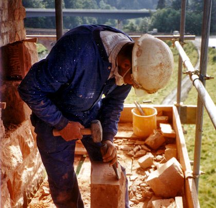 A craftsman makes adjustments to the new masonry.