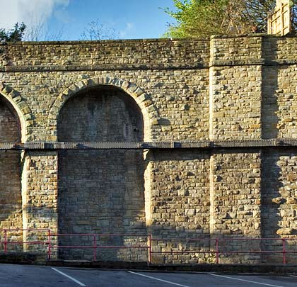 The huge retaining wall for the goods yard at the north end of North Bridge Viaduct incorporates a number of arches. These extend off the picture to the left whilst the viaduct's abutment is on the right.