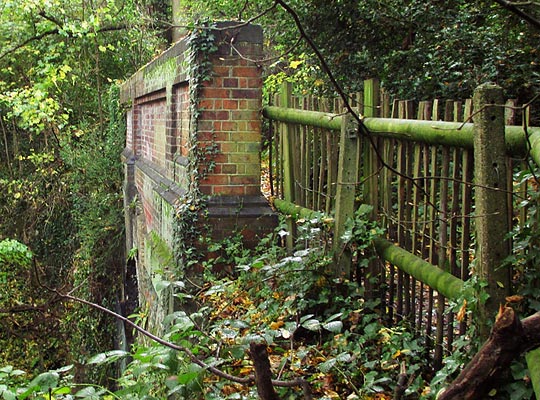 The substantial brick parapet, with rustic fencing either side.