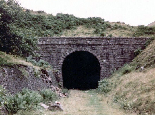The west portal pictured in 1980. Note the crumbling retaining wall fighting valiantly to hold back the cutting slope.