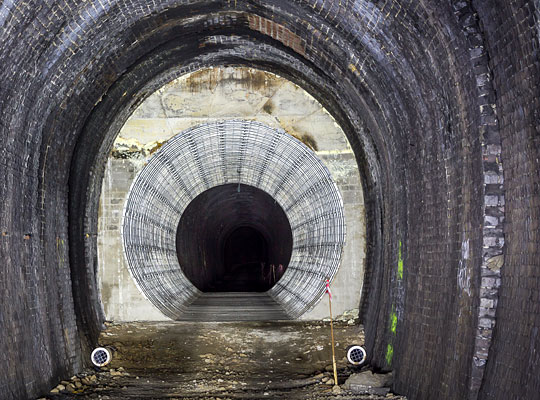 For 25 yards beyond the shaft, the tunnel’s section becomes circular with the installation of a corrugated steel liner, grouted behind with foamed concrete.