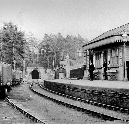 Two early railway employees pose for the camera on the platform at Glenfield Station, with the gloom of the tunnel over their shoulders.