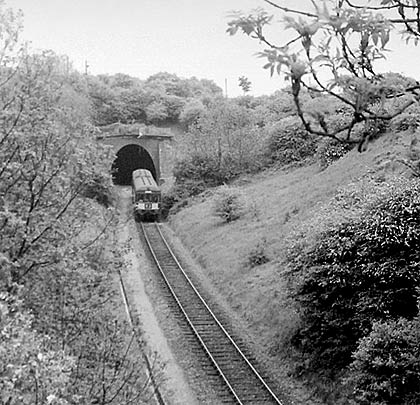 A DMU leaves the tunnel on its approach to Morcott Station.