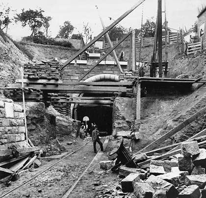 Much activity at the south end in 1898 as the portal's coping stones are craned into place.