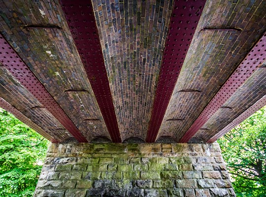At the eastern end of the viaduct, over Bank Top, is an iron girder span with brick jack arches.
