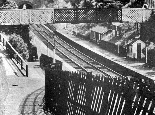 A view of the adjacent station in 1960, with the tunnel entrance peering over the footbridge.