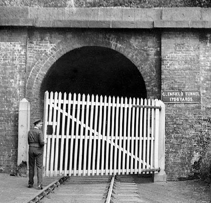 A porter closes one of the gates following the passage of a train. These were fitted to prevent the public entering but were removed in 1929.