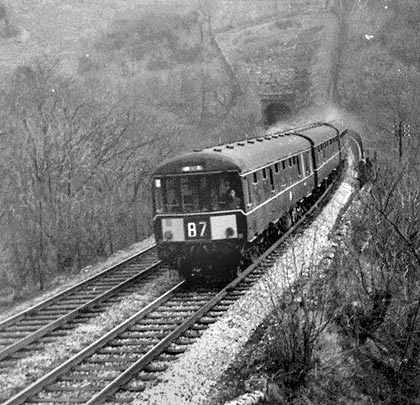 A Buxton-bound DMU leaves the tunnel to cross Monsal Dale Viaduct.