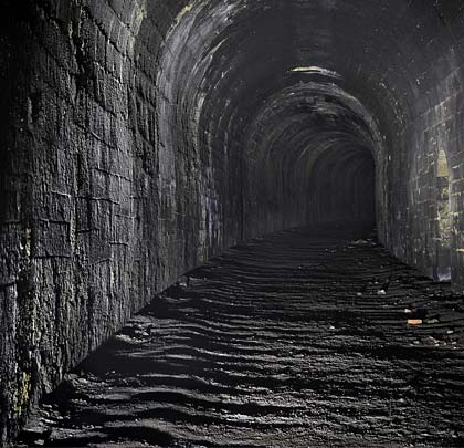 Still climbing, the soot-coated tunnel curves steadily to the east as the north portal is approached.