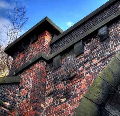 Largely brick-built, the portal features masonry corbels, copings, string course and rounded voussoirs, the latter being characteristic of Great Northern tunnels.