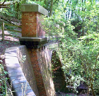 The portal boasts curved wing walls and a masonry-topped parapet.