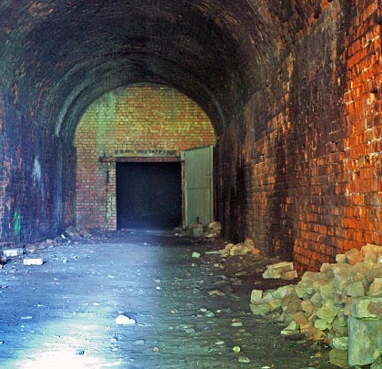 The accessible part of the tunnel is largely clutter-free but its brickwork is locally spalled.