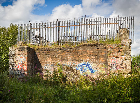 At the south end, the approach embankment has been removed to reveal the interior brickwork of the abutment.