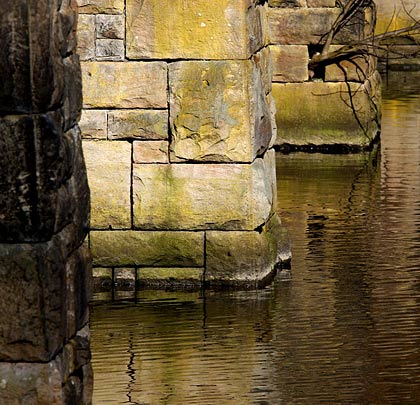 The piers are formed of rock-faced sandstone blocks.