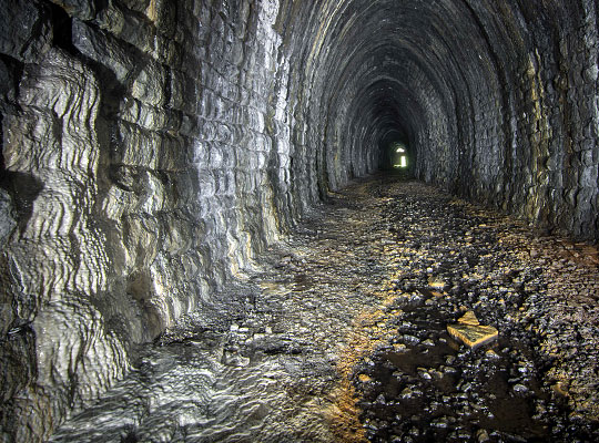 Inside, the tunnel suffers locally from water ingress, resulting in some extensive calcite deposits and ponding.