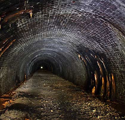 Brick-lined throughout, the tunnel has a circular profile near its ends...