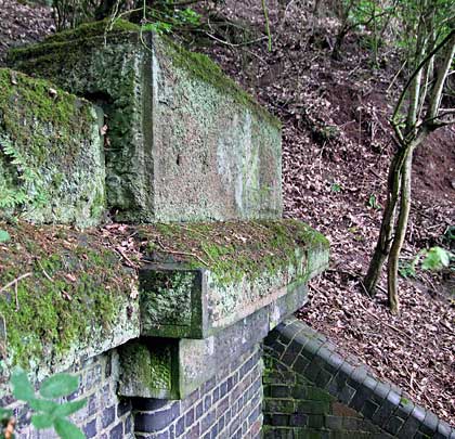 Substantial capstones adorn both ends of the portal's headwall.