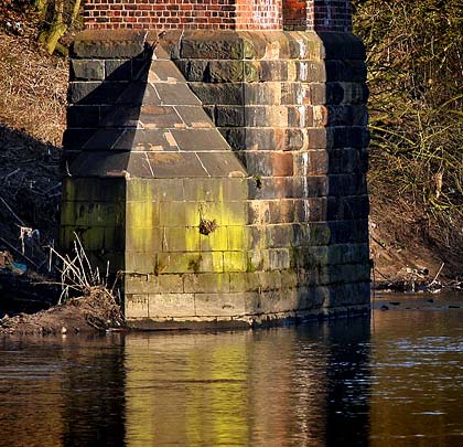 The two piers in the river have masonry feet and cutwaters.