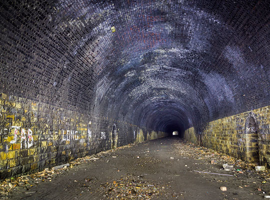 The tunnel is curved at both ends to follow an S-shaped alignment and has a falling gradient to the west.