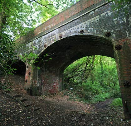 A heavily-pinned overbridge carries a minor road over the trackbed, just south of the old viaduct.