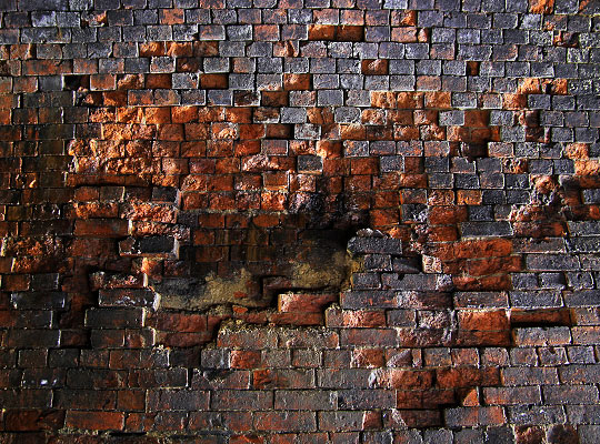 One of several patches of spalled brickwork.