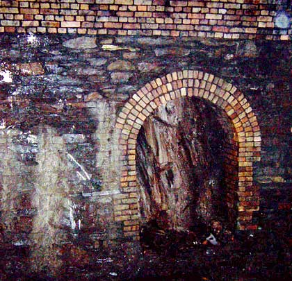 Masonry sidewalls support a brick arch. Some refuges reveal exposed rock at their rear.