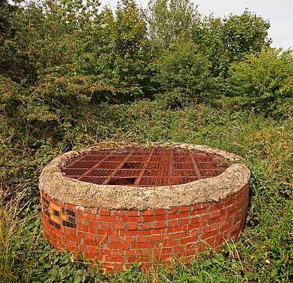 Much of the ventilation shaft's funnel was removed after closure, but its former concrete cap has been replaced by a grille.