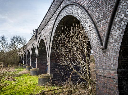 The existing viaduct, elegantly constructed by the Midland Railway in blue engineering brick, replaced an original timber structure.