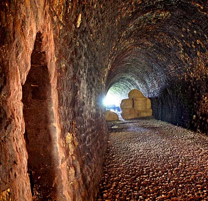 Masonry-lined, the tunnel is dry with a curve at its west end.