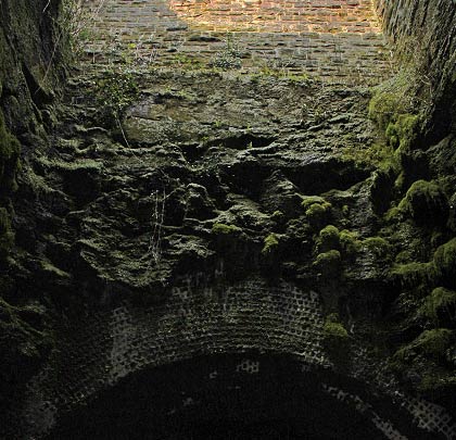 The crown of the arch is bearly 15 feet below ground level. Resisting the imposed load requires a 12-brick thick lining.