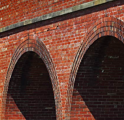A masonry string course sits about one foot above the arches.