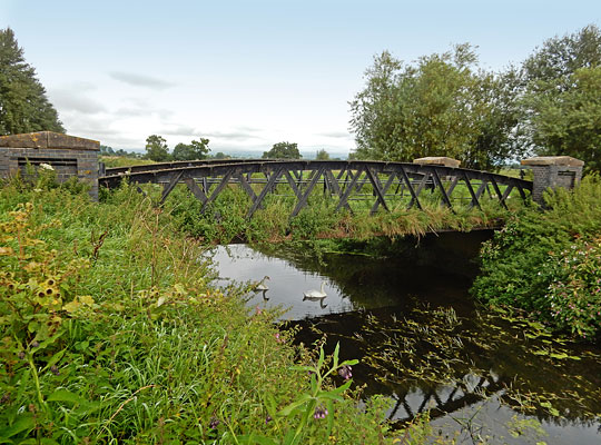 Now bedecked in vegetation, the single span stretches 43 feet across the River Brue.