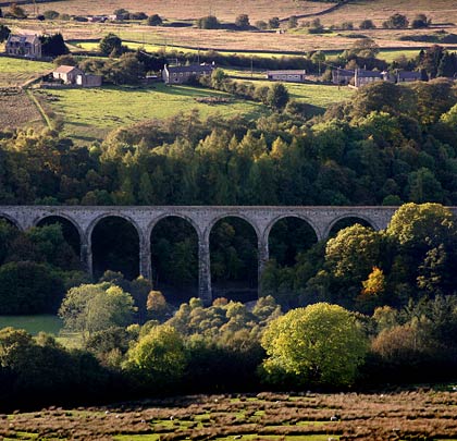 The viaduct spans a tight valley and is often in its shadow.