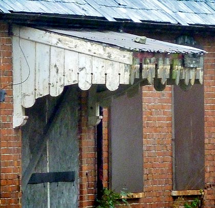 The building is boarded up but still retains some of its character.