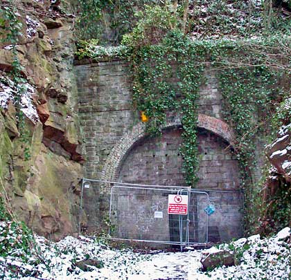 The northern portal, complete with burglar alarm, sits below a rock face and shows the lining at this end to be four bricks thick.