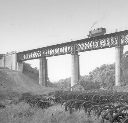 Back in time, the viaduct strides over a carpet of axles.