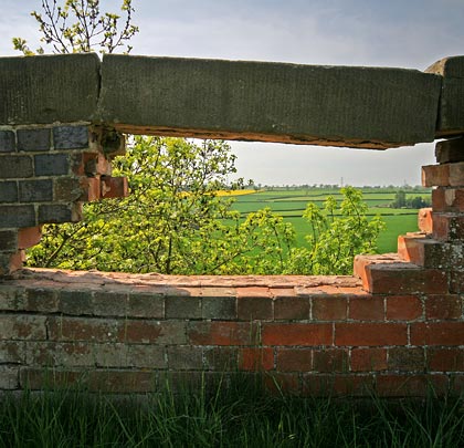 A substantial parapet stone waits for gravity to take its course.
