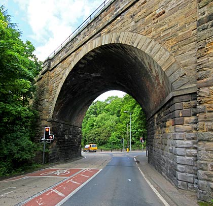 The easternmost span is skewed over the A7, featuring stone voussoirs and flanking buttresses.