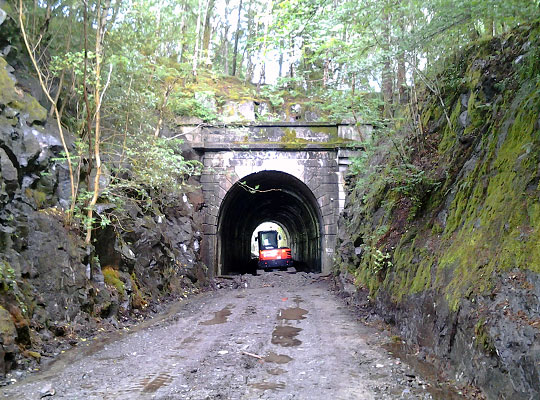 An excavator prepares the ground for a cycle path through the tunnel.