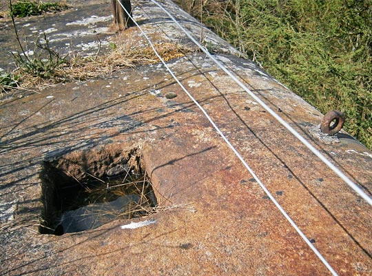 Cut into one of the parapet's capstones is a hole for a post.