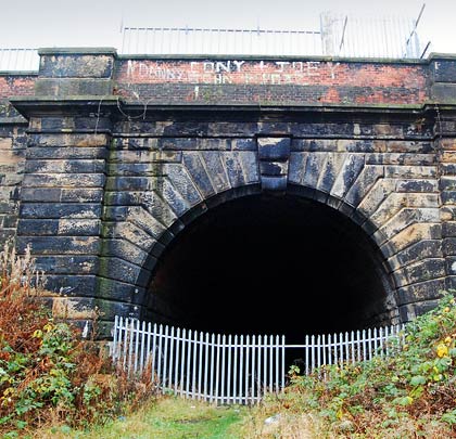 A substantial stone portal with brick parapets marks the eastern extent of the tunnels.