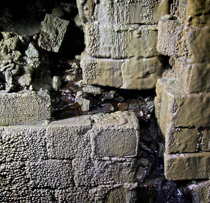 A hole is cut in the side wall, allowing a spring to drain into the tunnel.