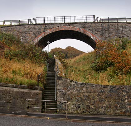 A set of steps connects North Deskford Street with the main road, passing beneath a bridge which once carried the railway.