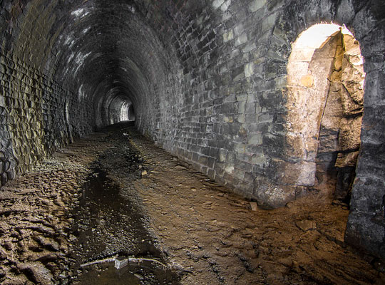 The tunnel initially curves to the west on a radius of about 19 chains before a short straight section is encountered at its southern end.