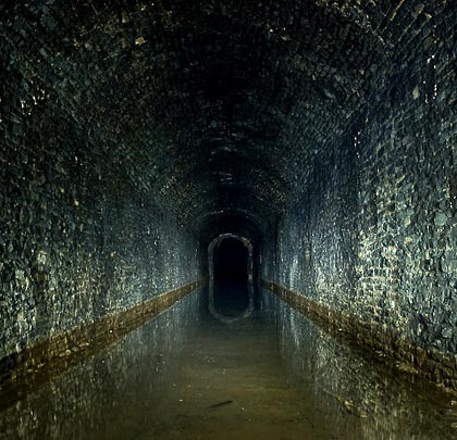 Water trapped in the tunnel perfectly mirrors the vertical walls.