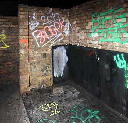 Graffiti adorns the urinals' walls.